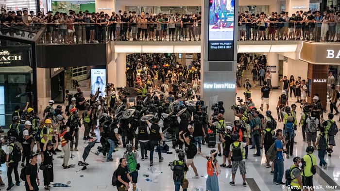 Riot police chase protesters through a shopping mall as they clash with protesters after taking part in a pro-democracy march on July 14, 2019 in Hong Kong